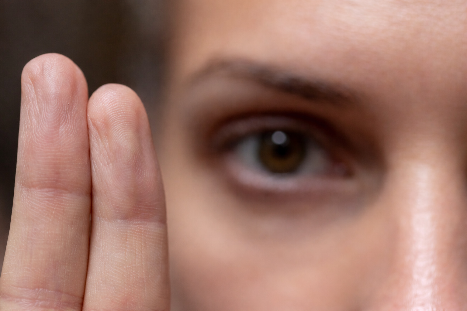 Close-up of a person focusing their eyes on two fingers during an Accelerated Resolution Therapy (ART) session.
