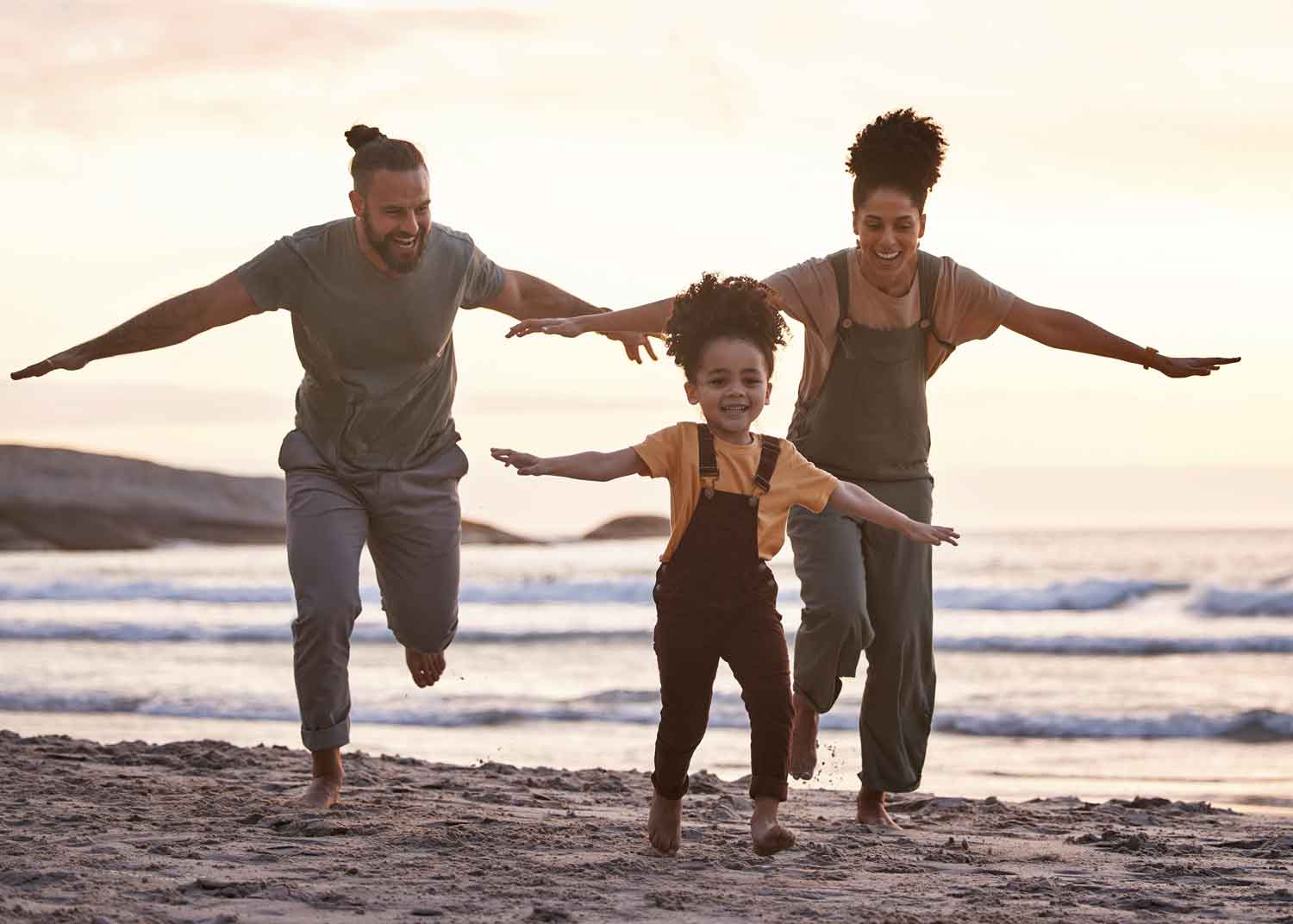 Family playing together on a beach, representing connection and emotional well-being
